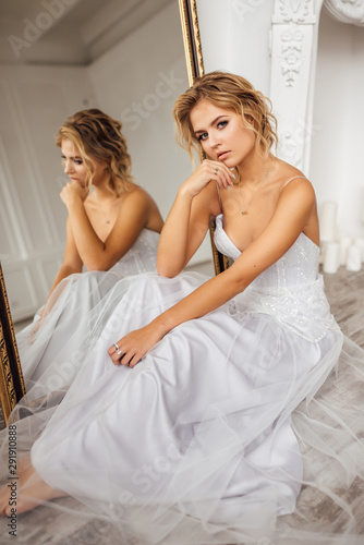 the bride in a beautiful dress sitting in the mirror
