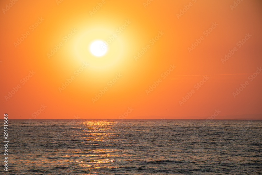 Sunset at sea during a beautiful golden hour. Landscape of the sun setting on the horizon.