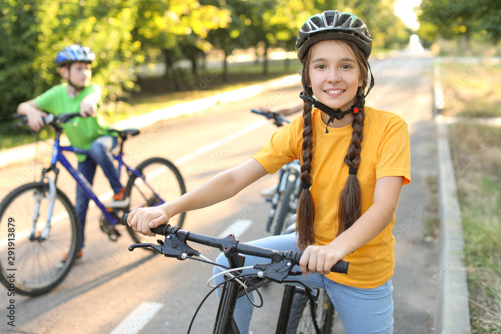 Naklejka premium Cute children riding bicycles outdoors