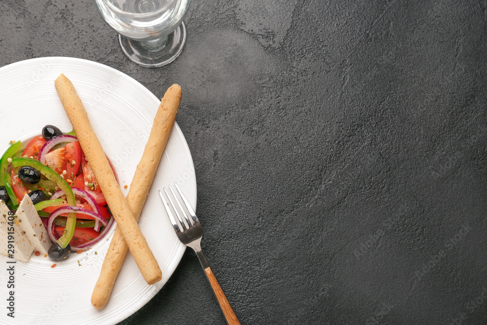Fototapeta premium Plate with tasty Greek salad on dark background