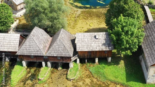 Croatia, countryside in region of Lika, Majerovo vrilo river source of Gacka, drone flying over traditional old wooden mills and cottages photo