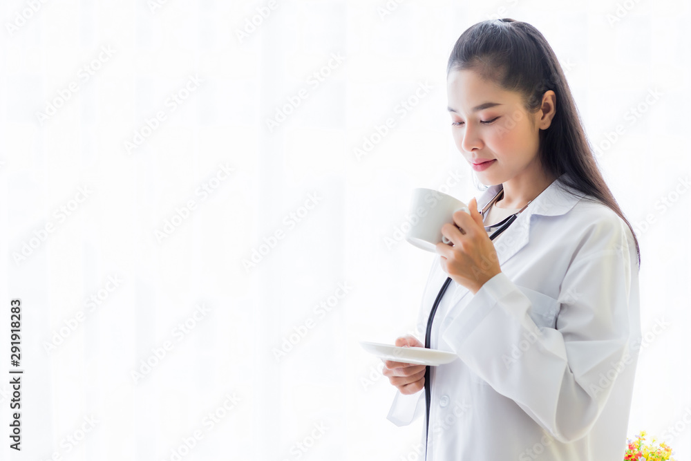 Portrait of asian young female doctor eating coffee from a cup and stethoscope with in hospital background. Portrait of asian young female doctor eating coffee from a cup and stethoscope with in hospital background.