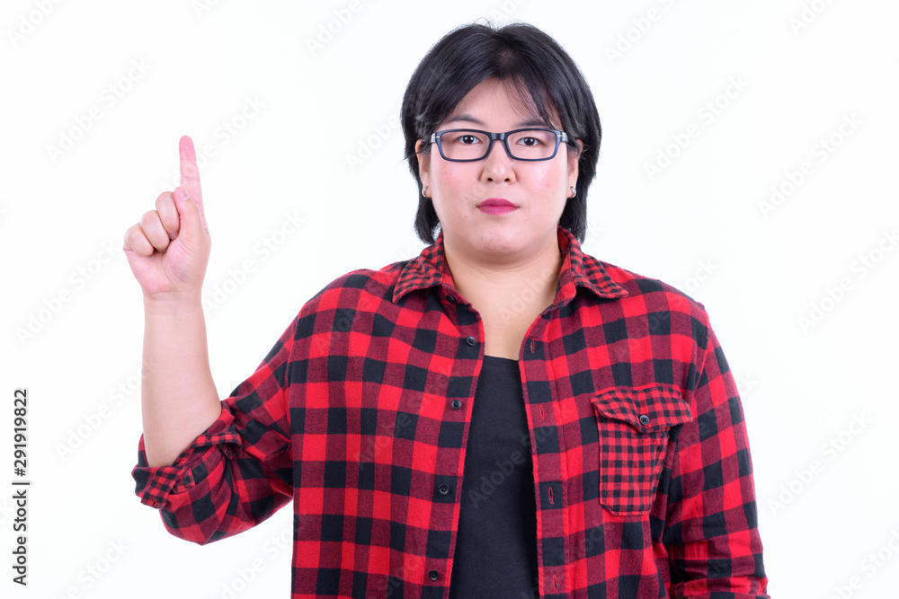 Beautiful overweight Asian hipster woman pointing up Beautiful overweight Asian hipster woman pointing up
