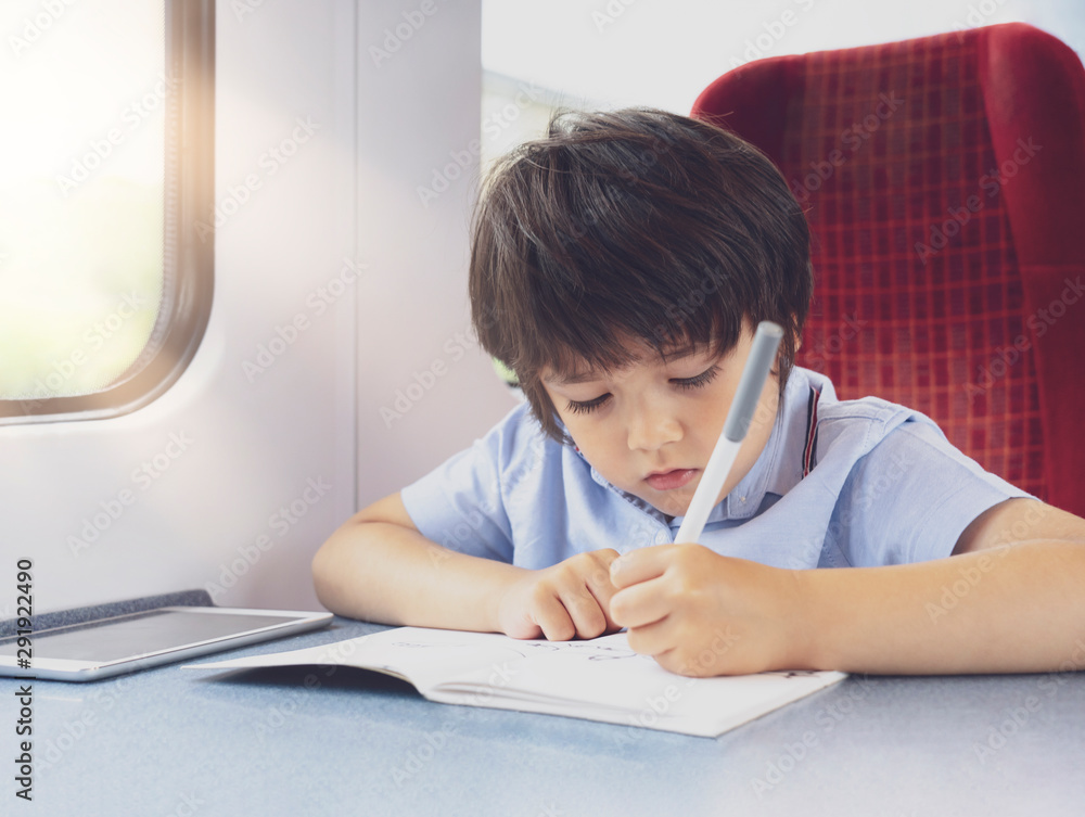 Kid traveling by the train, Child drawing or watching cartoon on teplet sitting by the window. Little boy in a high speed express train on family vacation, Entertainment for young passenger. Kid traveling by the train, Child drawing or watching cartoon on teplet sitting by the window. Little boy in a high speed express train on family vacation, Entertainment for young passenger.