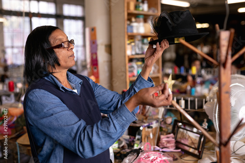 Woman holding a hat in a hat factory photo