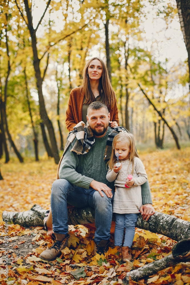 Family in a autumn park. Woman in a red sweater. Cute childrens with parents Family in a autumn park. Woman in a red sweater. Cute childrens with parents