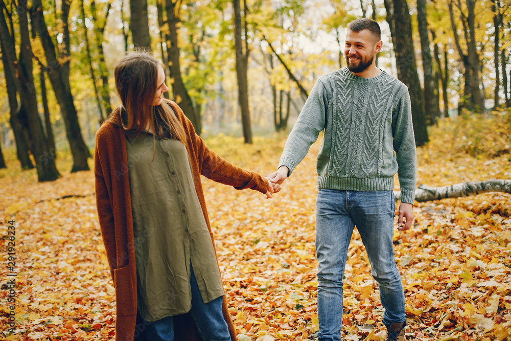 Couple in a park. Woman in a brown sweater. Man with a beard Couple in a park. Woman in a brown sweater. Man with a beard