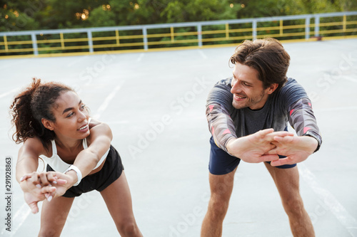 Sports couple man and woman make stretching exercises