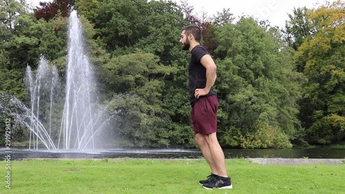 Man doing lunges in park near fountain