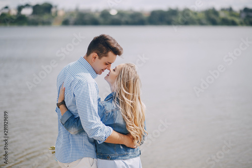 beautiful long-haired blonde with her handsome man wallkinh near water on the beach © prostooleh