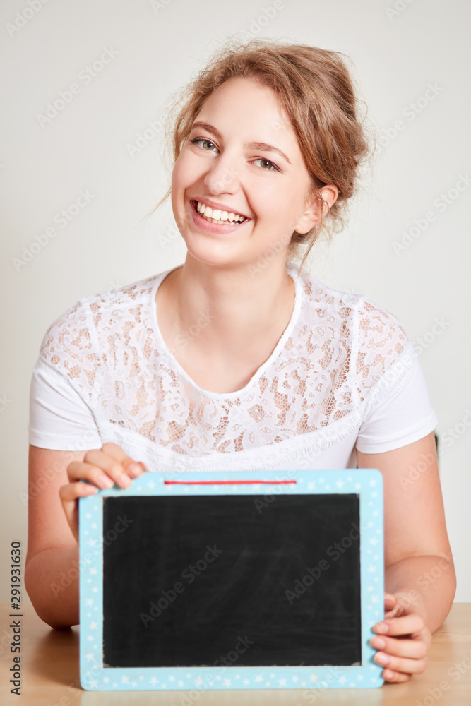 Woman is holding empty chalkboard in her hands Woman is holding empty chalkboard in her hands