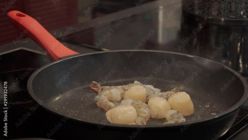 Spicing shrimp and scallops fried on the pan. Italian cuisine Spicing shrimp and scallops fried on the pan. Italian cuisine