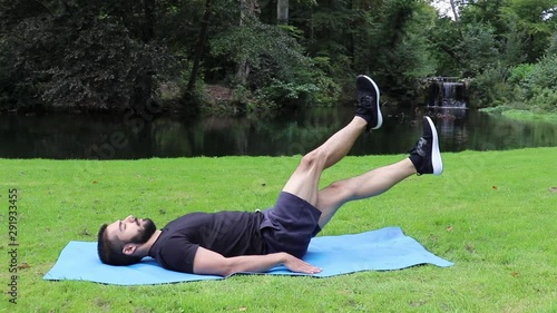Man training abs scissors in park