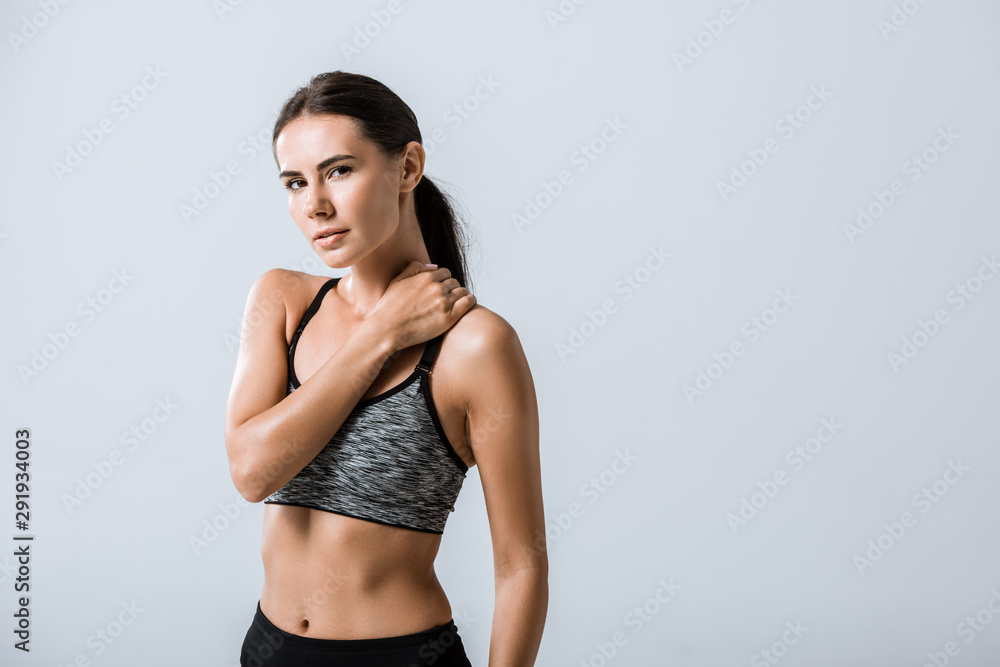 Fototapeta premium attractive sportswoman with neck pain isolated on grey