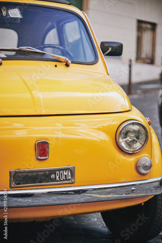  Detail view of an old Fiat 500 car typical of Italy in yellow color parked