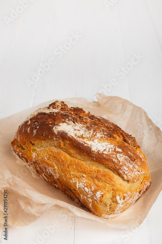 Homemade bread in baking paper on a white background