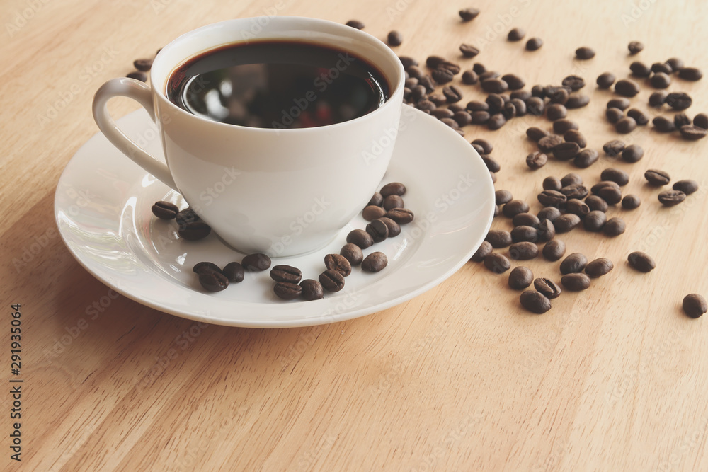 cup of coffee and beans on wooden table cup of coffee and beans on wooden table