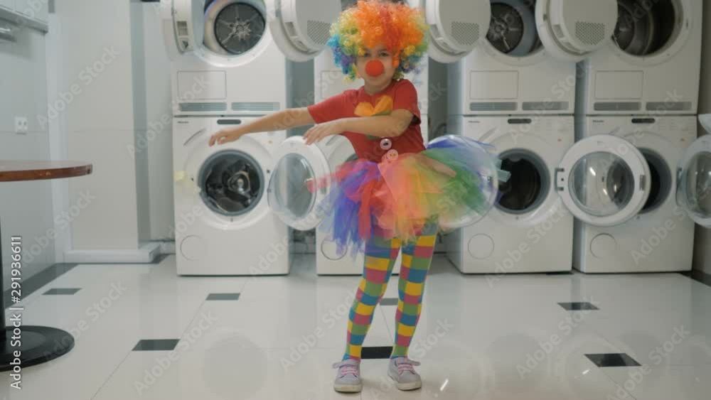 Happy Clown Little Girl Dancing And Have Fun In the Laundry Room. Little Child Clown Enjoying