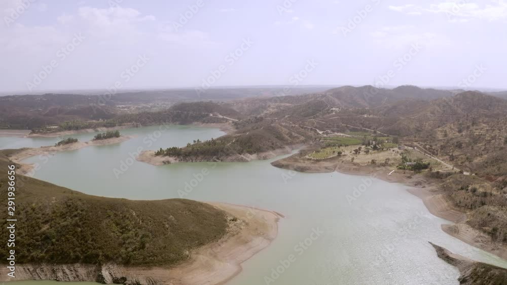 Areal view of a water reservoir for drinking water and energy in portuguese algarve region. Drone flight over the huge barrage for water extraction in the south of Portugal. Areal view of a water reservoir for drinking water and energy in portuguese algarve region. Drone flight over the huge barrage for water extraction in the south of Portugal.