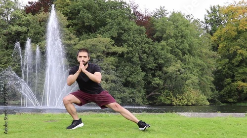 Man side lunge in park near fountain