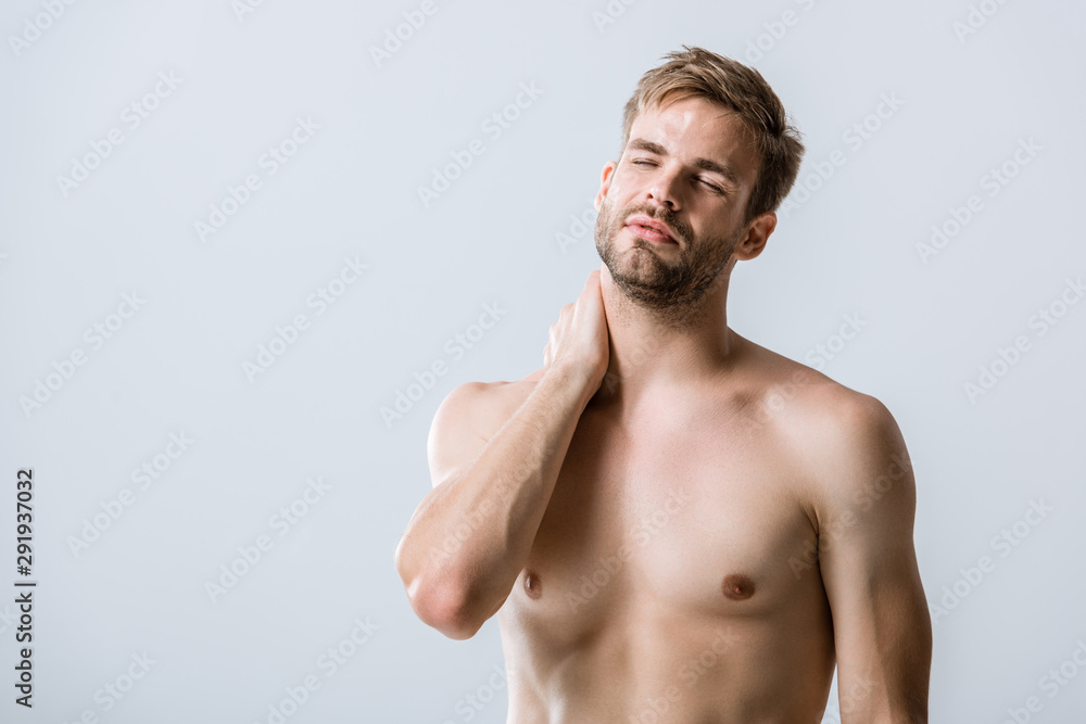 shirtless bearded man with neck pain isolated on grey shirtless bearded man with neck pain isolated on grey