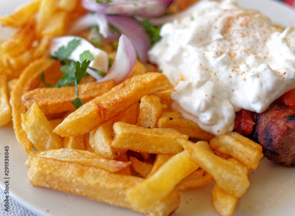 spicy kebab plate with pita bread, onions, fried potatoes, and tzatziki sauce spicy kebab plate with pita bread, onions, fried potatoes, and tzatziki sauce
