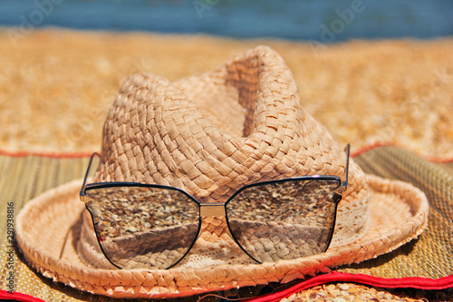 Summer background. Glasses and hat on the background of shells and the sea