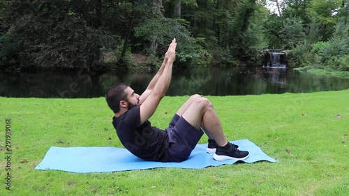 Man sit ups arms up in park