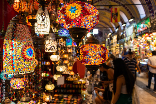 Souvenir store in big bazaar, people observing traditional lamps in the shop photo