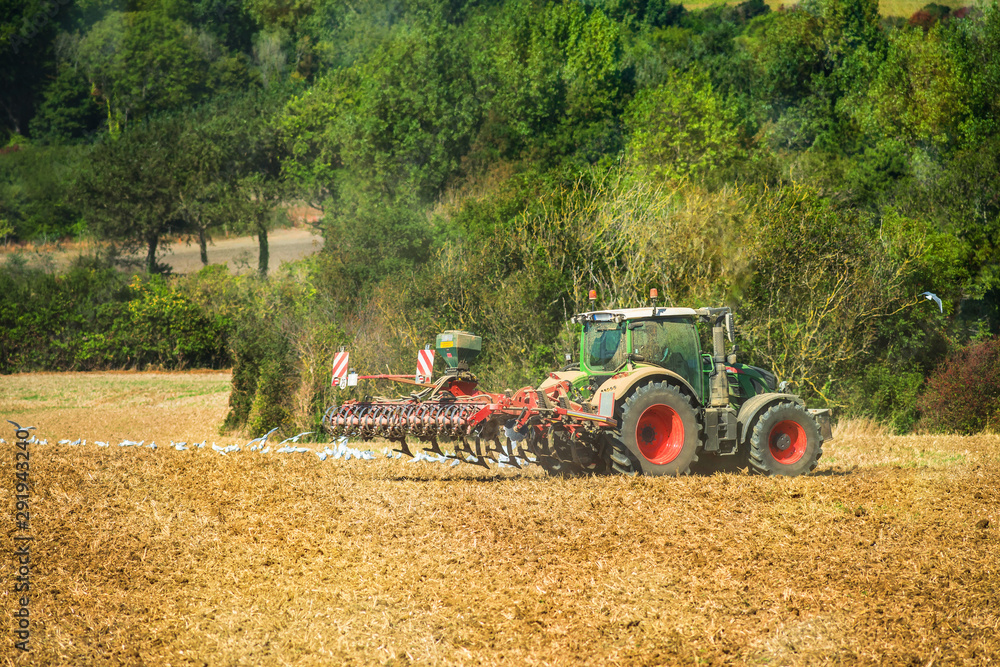 Fototapeta premium tracteur et sa remorque pour labourer les champs dans un joli paysage