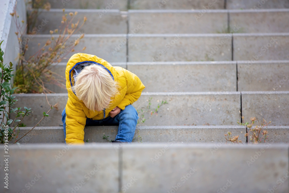 Blonde little toddler child in yellow jacket, playing on the playground Blonde little toddler child in yellow jacket, playing on the playground