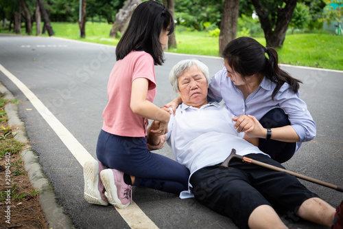 Sick asian senior mother with heat stroke,high temperature,vertigo on floor after falling down,daughter,granddaughter to help,take care of elderly fell faint,exhausted,suffering from illness,sunburn
