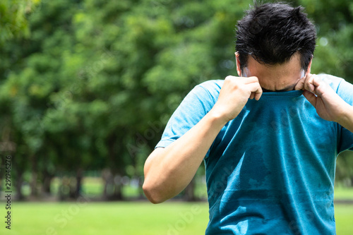 Obraz na plátne Asian young man feel bad,smelling something stinks,sniffing his wet armpit or sw