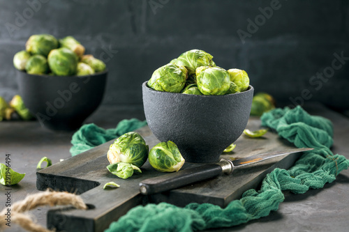 Foto Fresh raw brussels sprouts on a dark wooden table