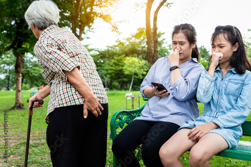 Asian daughter and granddaughter holding breath with fingers on nose,something stinks,senior mother holding her bottom,elderly woman have gas in digestive tract,farting make a bad smell while walking