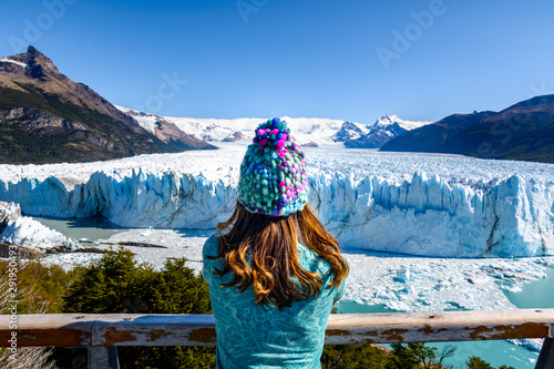 A female tourist is standing in front of Perito Moreno Glacier, Los Glaciares National Park in Santa Cruz Province, Argentina