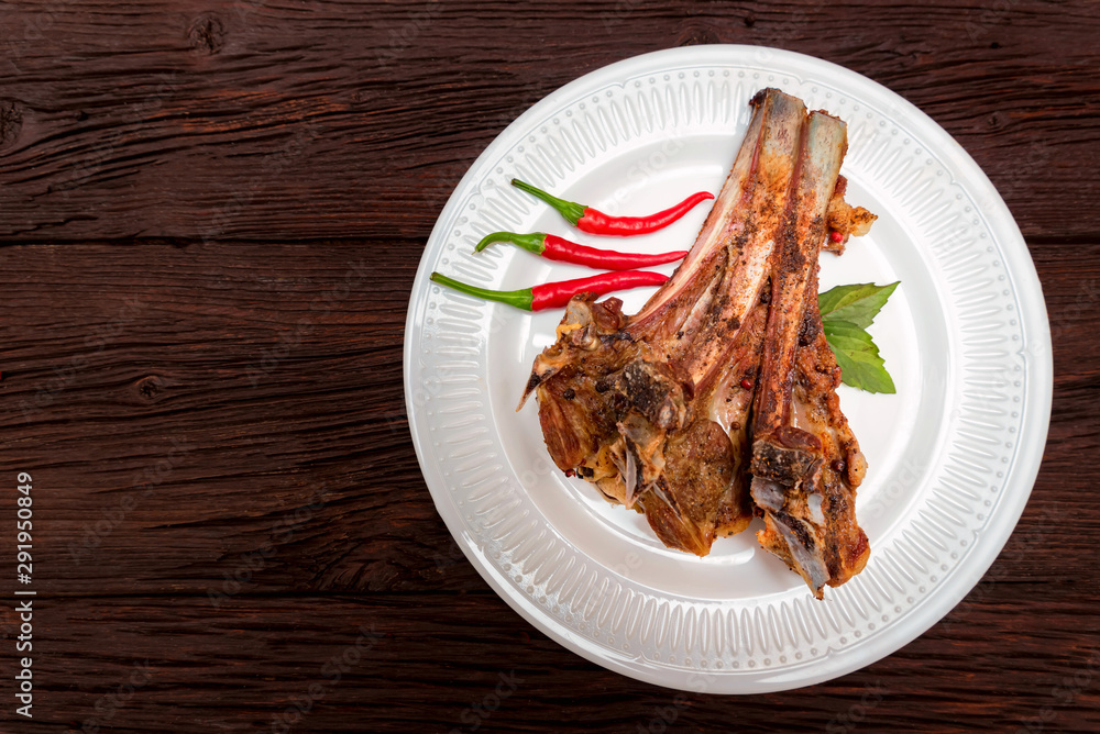 Roasted lamb ribs served on plate. Top view Roasted lamb ribs served on plate. Top view