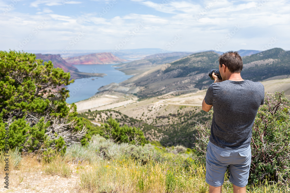 Man taking picture of Sheep Creek Overlook in Manila, Utah near Flaming Gorge National Park with cloudy valley and river