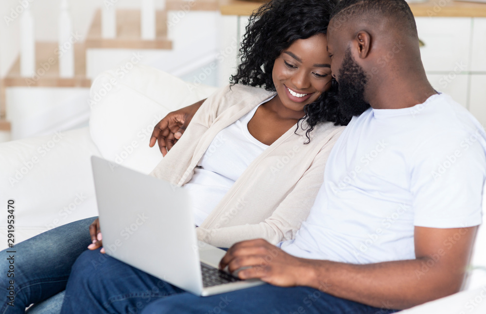 Black couple spending weekend together, watching movie on laptop Black couple spending weekend together, watching movie on laptop
