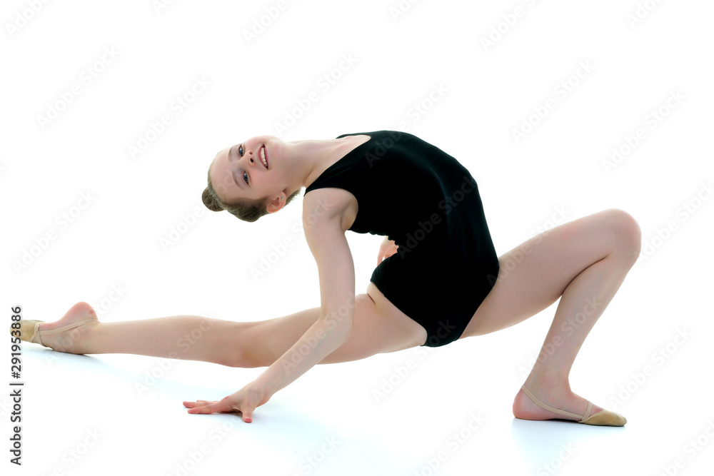 The little gymnast perform an acrobatic element on the floor. The little gymnast perform an acrobatic element on the floor.