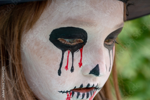 Halloween .. Holiday Day of the Dead. Close-up portrait of a witch girl. The monster comes out of the dark. photo