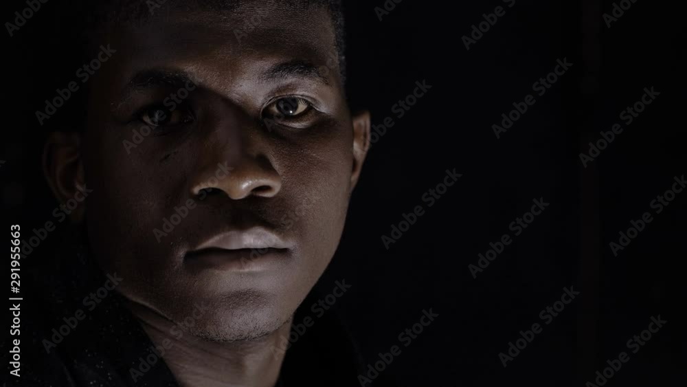 Sad proud Black African Migrant looking At Camera In The Darkness Sad proud Black African Migrant looking At Camera In The Darkness