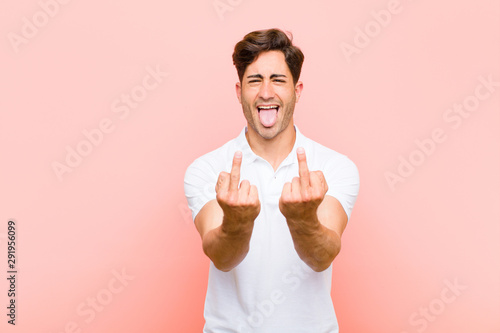 Foto young handsome man feeling provocative, aggressive and obscene, flipping the mid