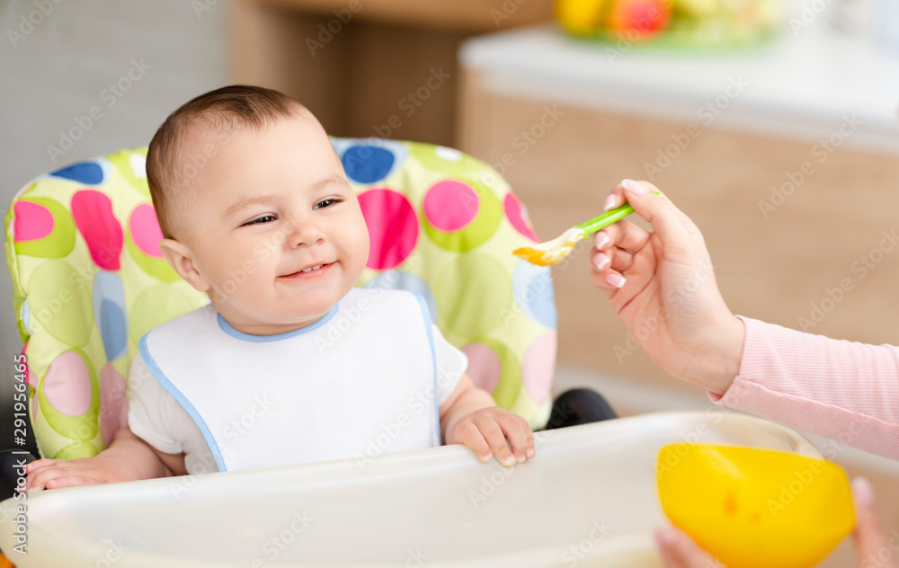 Mother feeding cute baby with tasty porridge Mother feeding cute baby with tasty porridge