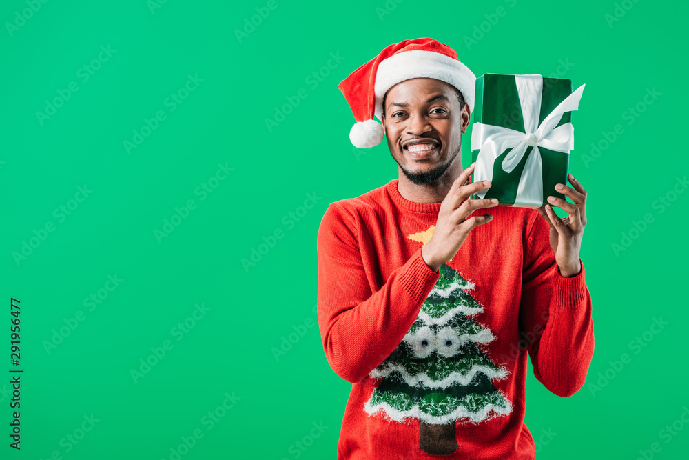 African American man in Christmas sweater and Santa hat holding