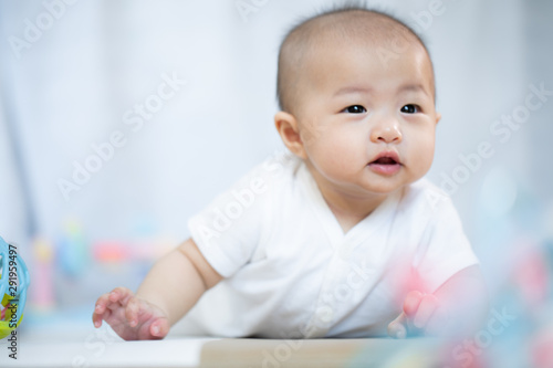 Asian baby happy in the room.Asian baby girl lying down on bed .