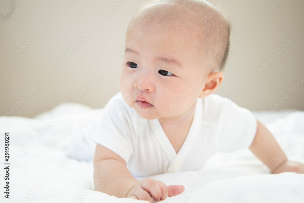 Asian baby happy in the room.Asian baby girl lying down on bed .