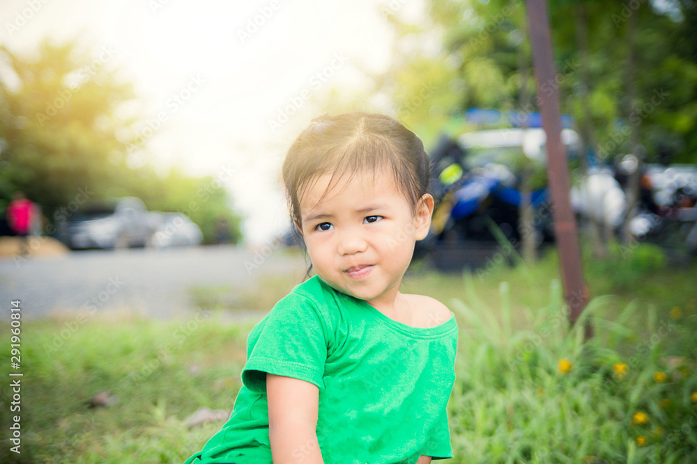 .The girl is wearing a green shirt. Playing in the grass .The girl is wearing a green shirt. Playing in the grass