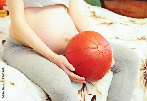  Teenage pregnancy is pregnancy in human females under the age of 20. Pregnant woman holding sport ball