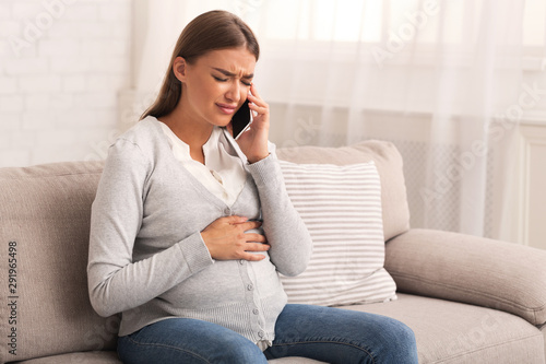 Pregnant Girl Talking On Cellphone Suffering From Pain At Home